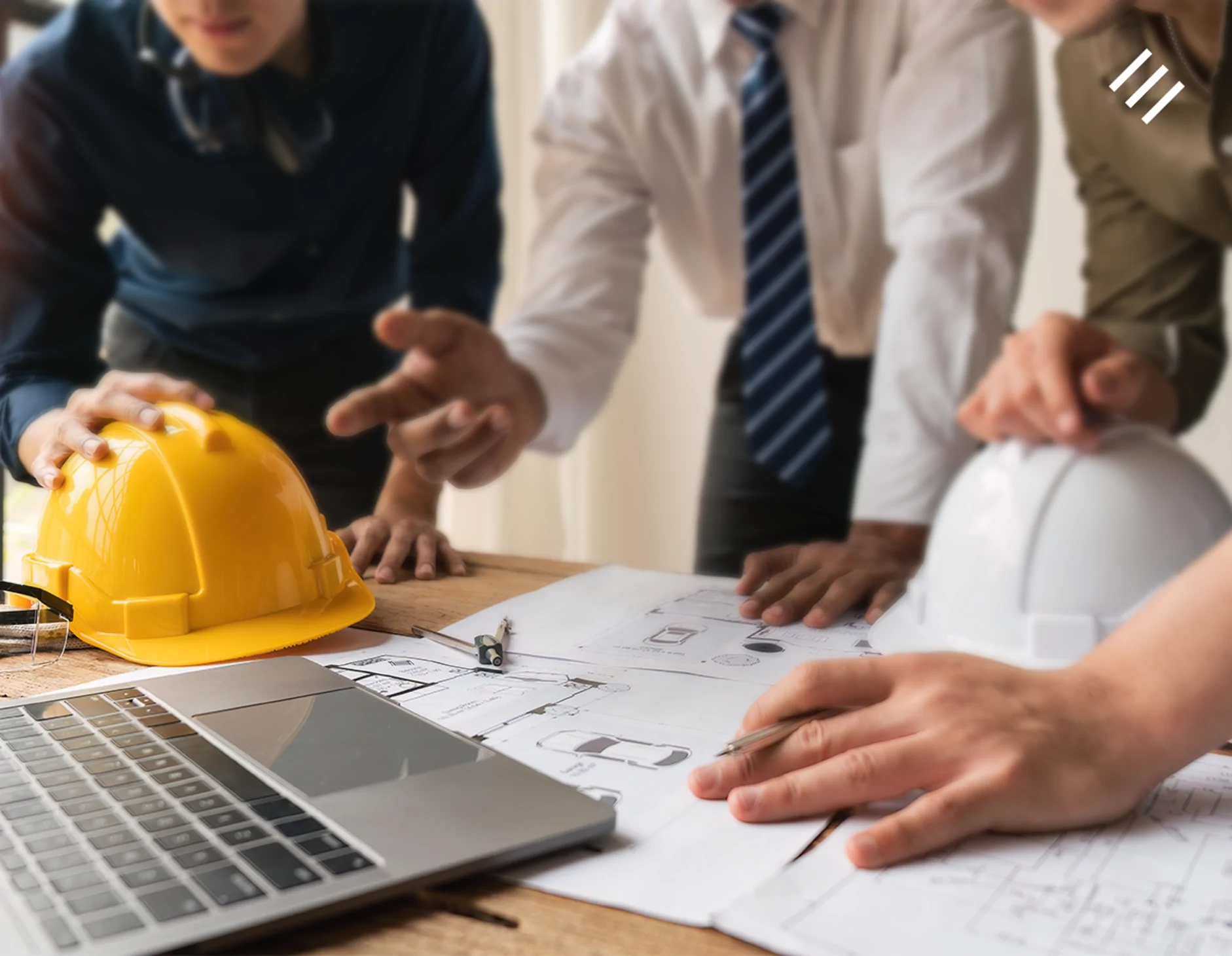 três homens em reunião sobre incorporação imobiliária