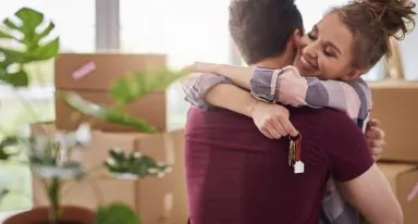 Happy couple with keys of new apartment